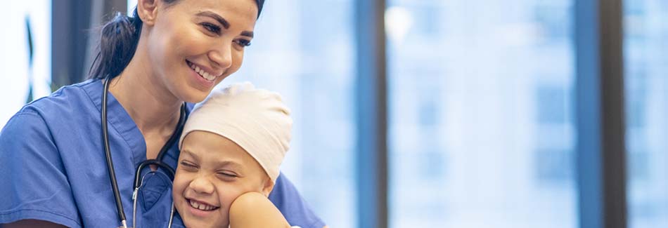 Nurse hugs a young patient at Baptist’s cancer treatment center in Jackson