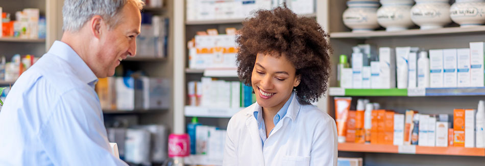 Pharmacist at the counter providing a cancer patient with specialized pharmacy services.