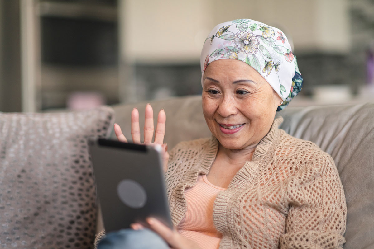 female cancer patient smiles while participating in online support group