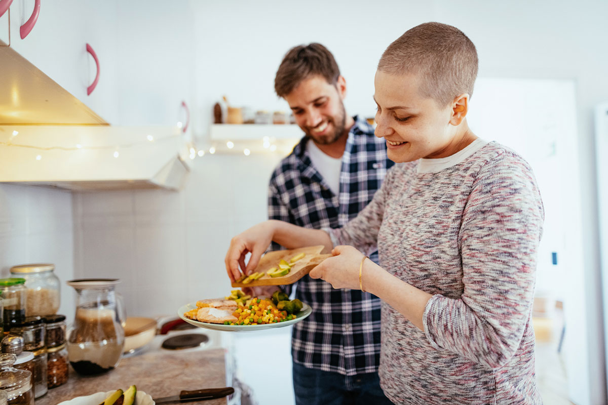 cancer patient prepares food in a kitchen