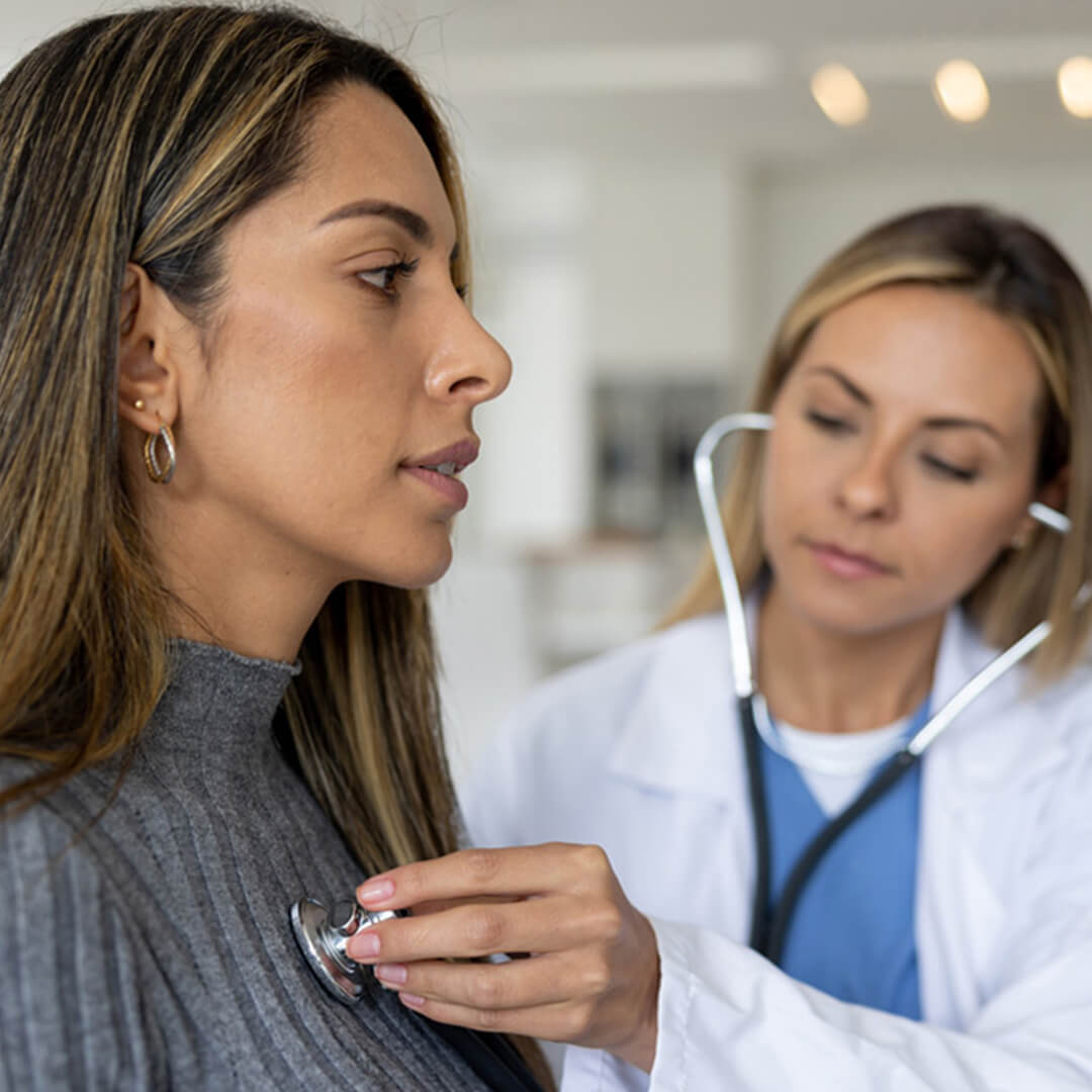 A doctor examining a patient using a stethoscope